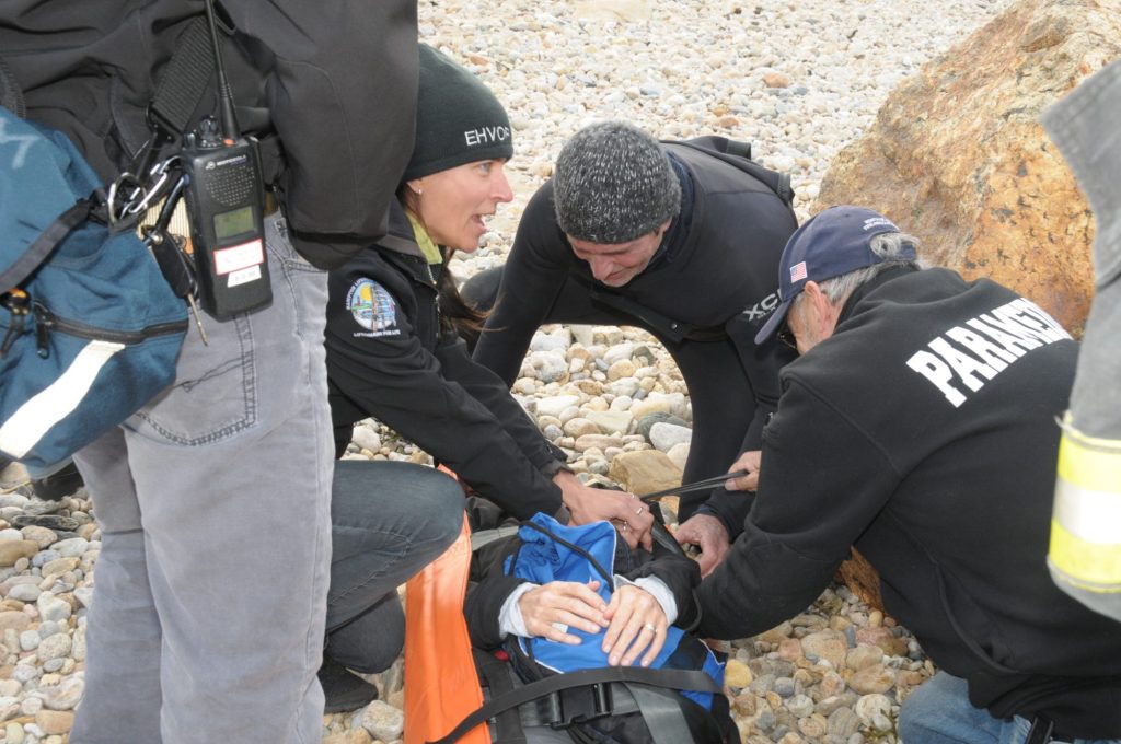 Rescue volunteers work on a mannequin at the beach.